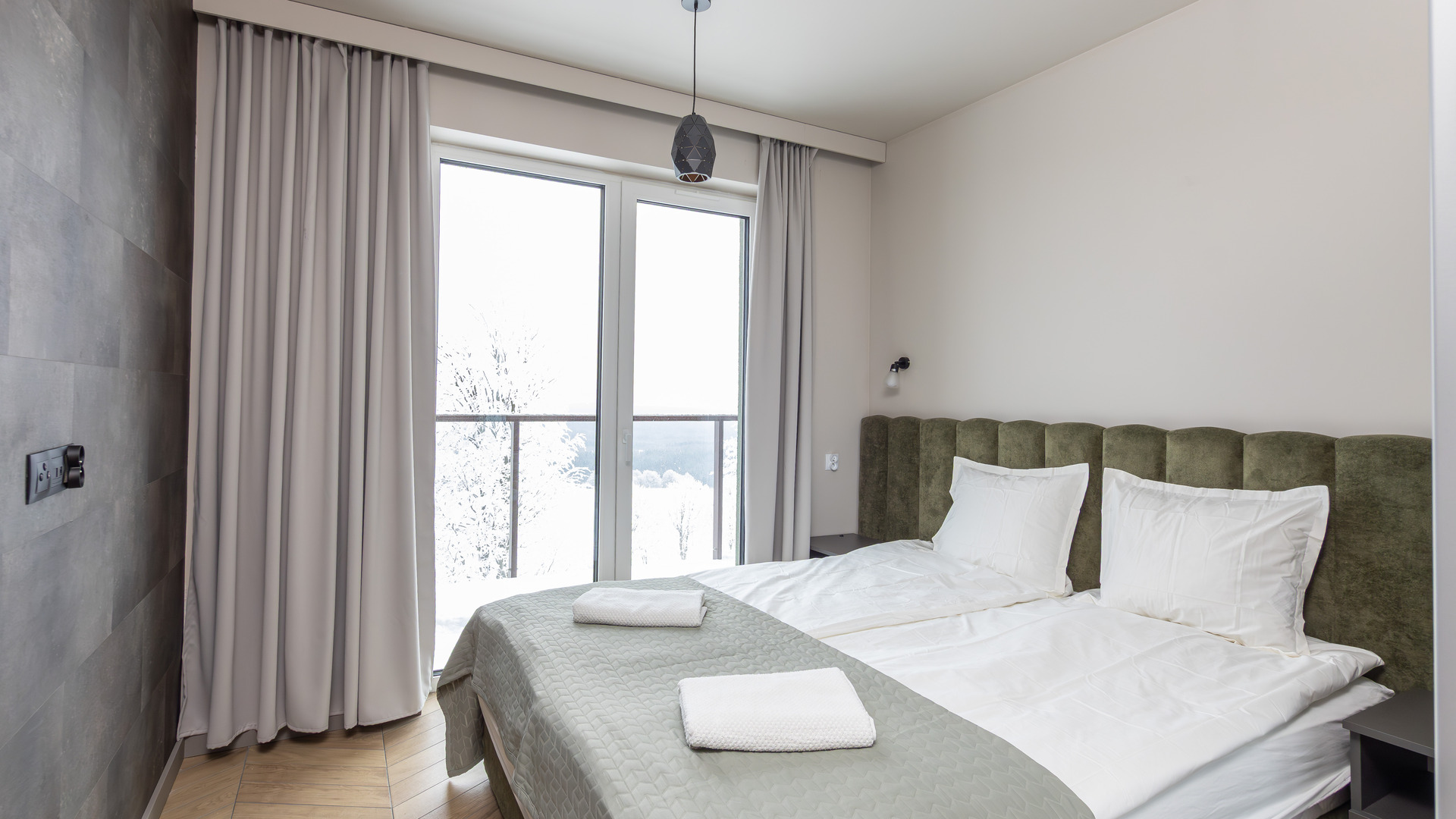 Weekend narciarski w Zieleńcu: sypialnia apartamentu Willi Zieleniec z zaśnieżonym lasem za oknem balkonowym