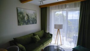 Weekend we dwoje w górach: salon apartamentu w Willi Zieleniec z zieloną sofą, wyjściem na balkon i widokiem na góry